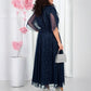 Büyük beden, lacivert midi elbise, simli detayları ve dökümlü pelerin kollarıyla dikkat çekiyor.